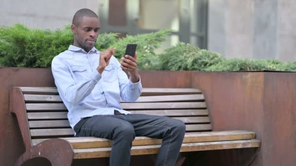 雄心勃勃的非洲男人在智能手机上庆祝成功 — 图库视频影像