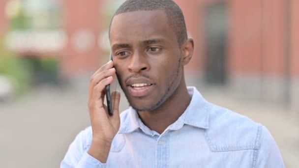 Ritratto all'aperto di allegro uomo africano che parla su Smartphone — Video Stock