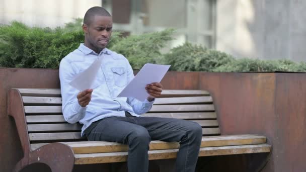 アフリカ人男性は屋外で文書を読んだ後に不満と失望 — ストック動画