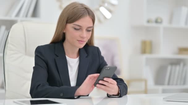 Seriöse Geschäftsfrau nutzt Smartphone im Büro — Stockvideo