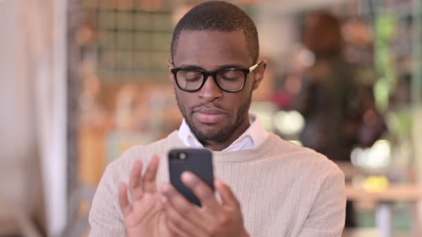 Portret van verstoorde Afrikaanse Man met verlies op Smartphone — Stockvideo