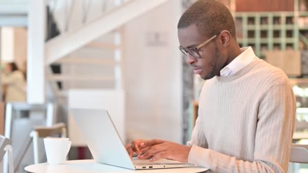 Uomo africano che lavora su Laptop Pointing presso la fotocamera in Cafe — Video Stock