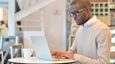 Cafe 'de laptopla çalışan odaklanmış Afrikalı Adam