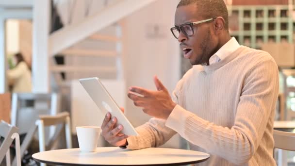 Besviken afrikansk man som reagerar på Loss on Tablet i Cafe — Stockvideo