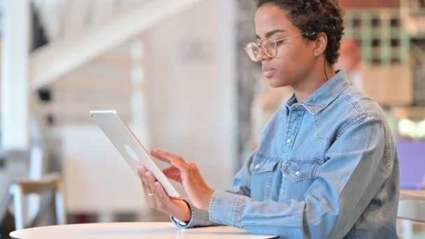 Mujer africana joven seria usando Tablet en Café — Vídeos de Stock