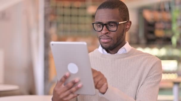 Portrait de jeune homme africain ambitieux utilisant une tablette numérique — Video