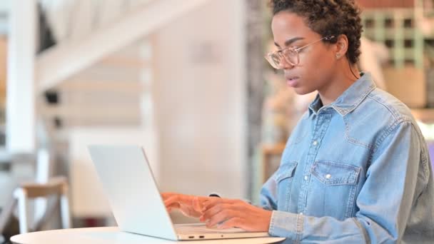 Glückliche Afrikanerin macht Videoanruf auf Laptop im Cafe — Stockvideo