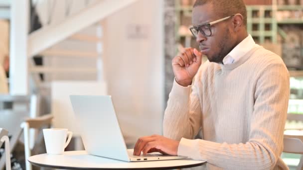 Sjuk afrikansk man med laptop hosta i Café — Stockvideo