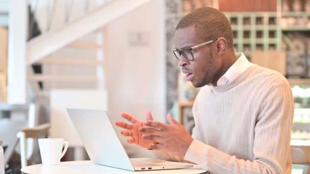 Pérdida, Hombre Africano reaccionando al fracaso en el ordenador portátil en Café — Vídeos de Stock