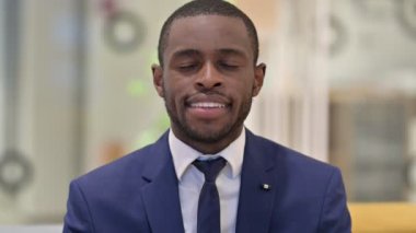 Kameraya gülümseyen neşeli Afrikalı iş adamının portresi