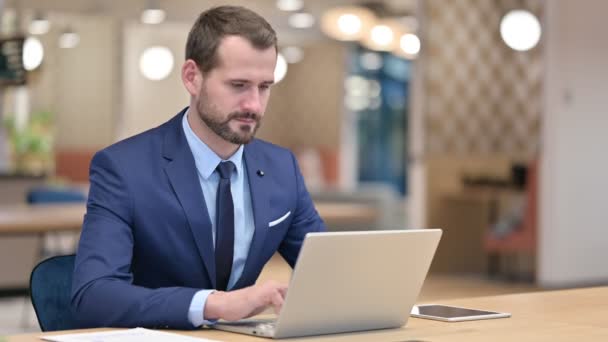 Seriös affärsman med laptop Tittar på kameran — Stockvideo