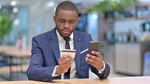 Успех онлайн-платежей на смартфоне для африканского бизнесмена — стоковое видео