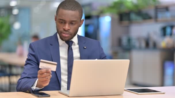 Успіх онлайн платежів на ноутбуці для африканського бізнесмена в офісі — стокове відео