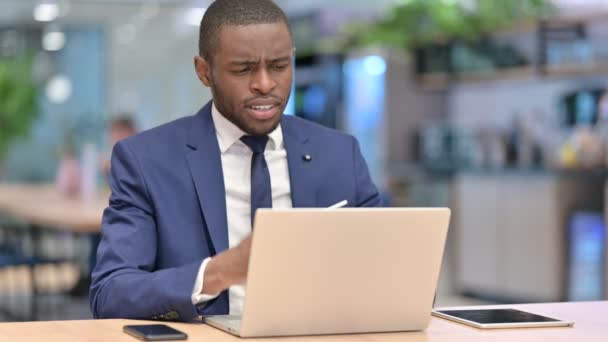 Pérdida, empresario africano reaccionando al fracaso en el ordenador portátil en la oficina — Vídeos de Stock