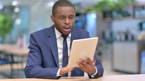 Uomo d'affari africano che celebra il successo sul tablet in ufficio — Video Stock