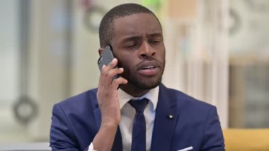 Akıllı telefondaki Neşeli Afrikalı İş Adamının Portresi