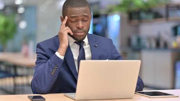 Stresszes afrikai üzletember laptoppal, akinek fáj a feje az irodában — Stock videók