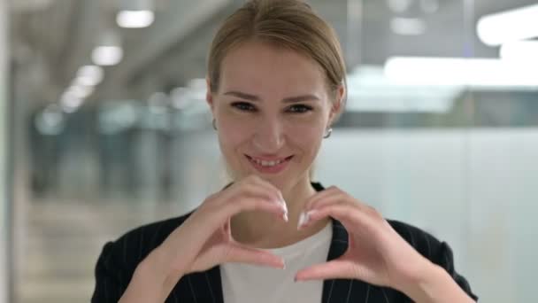 Portrait de femme d'affaires montrant signe de coeur avec la main — Video
