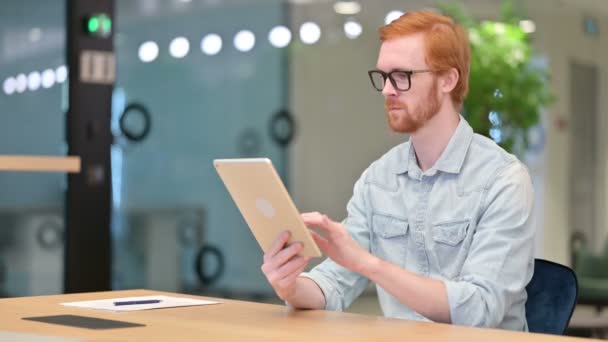 Sérieux professionnel occasionnel rousse homme en utilisant la tablette dans bureau — Video