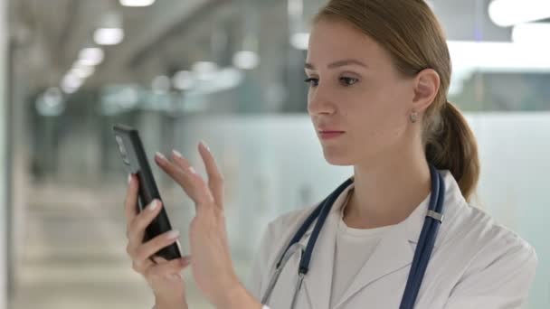 Porträtt av attraktiv kvinnlig läkare med hjälp av smartphone — Stockvideo