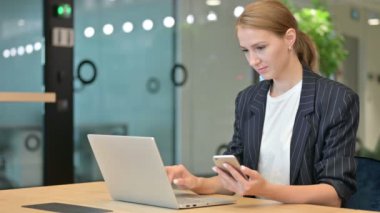 Akıllı telefon ve dizüstü bilgisayar kullanan iş kadını 