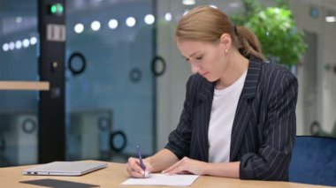 Ciddi İş Kadını Ofiste Kağıda Yazıyor 