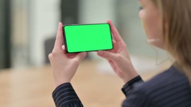 Krom Ekran ile Akıllı Telefon İzleyen İş Kadını Arka Görünümü 