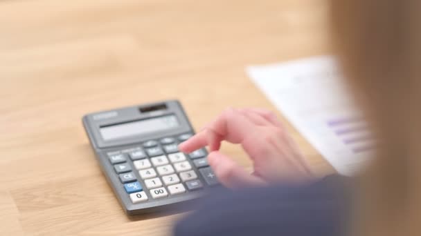 Achteraanzicht van handen met behulp van Calculator in close-up — Stockvideo