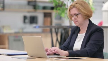 Laptop 'u olan yaşlı iş kadını işaret göstermiyor 