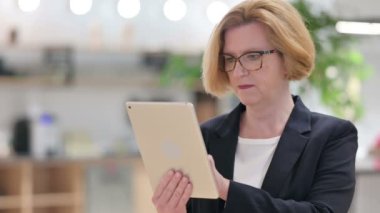 Tablette Başarı Kutlaması Yapan Heyecanlı Yaşlı İş kadınının Portresi 