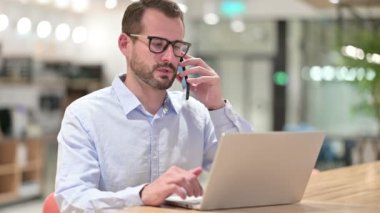 Bilgisayarlı İşadamı Ofiste Akıllı Telefonla Konuşuyor 