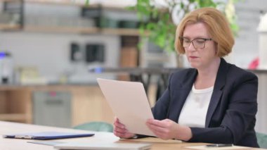 Ofiste Belge Okuma ve Kutlama İçin Heyecanlı Yaşlı İş Kadını 