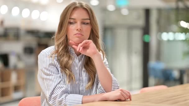 Беспокойная деловая женщина, сидящая в офисе и думающая — стоковое видео