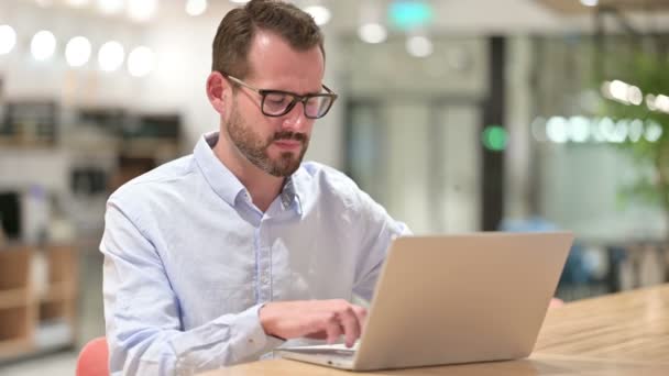 Empresário estressado com laptop com dor de cabeça no escritório — Vídeo de Stock