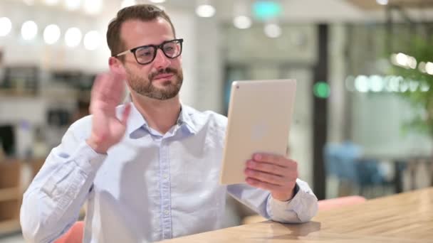 Бизнесмен делает видеозвонок на планшете в офисе — стоковое видео