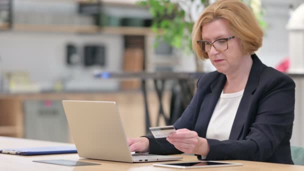 Mulher de negócios velha com pagamento em linha bem sucedido no portátil no escritório — Vídeo de Stock