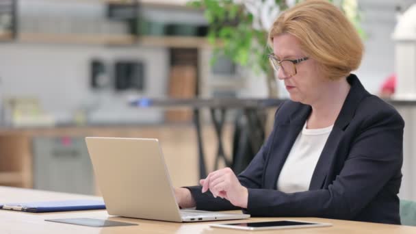 Velha empresária com perda no laptop no escritório — Vídeo de Stock