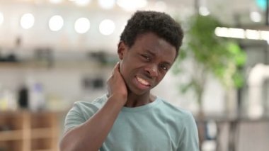 Dizüstü bilgisayarı olan, boynu ağrıyan genç bir Afrikalı. 