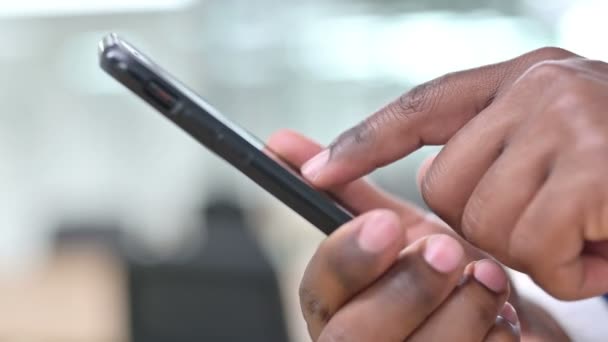 Primer plano de la mensajería de texto de mano africana en el teléfono inteligente — Vídeo de stock