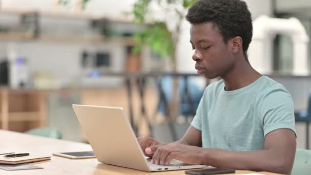 Mladý Afričan s laptopem ukazujícím na kameru — Stock video