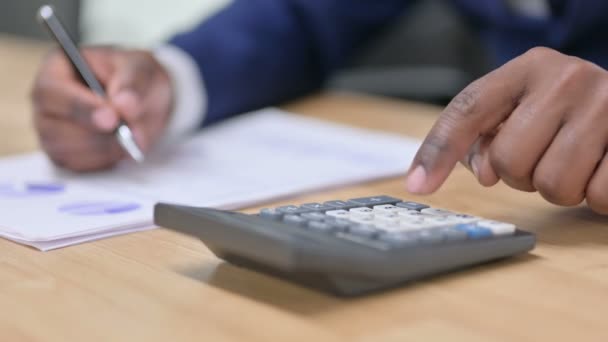 Primer plano del empresario africano usando la calculadora en el trabajo — Vídeos de Stock