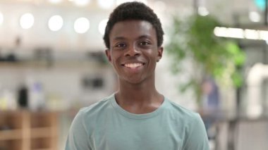 Kameraya bakan gülümseyen genç Afrikalı adamın portresi 