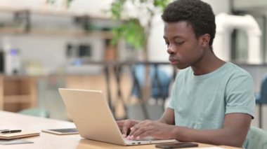 Laptop öksüren hasta bir Afrikalı.