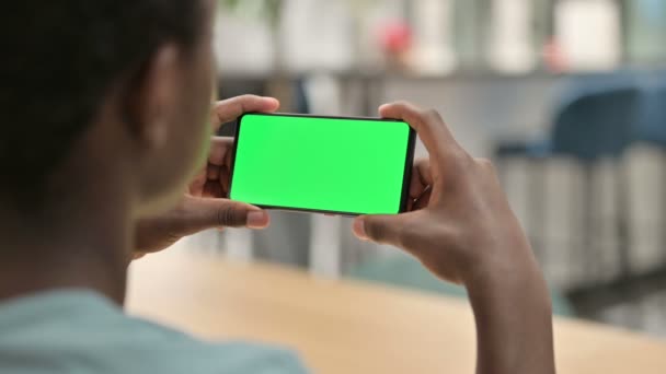 Αφρικανός άνθρωπος βλέποντας Smartphone με πράσινο Chroma οθόνη — Αρχείο Βίντεο
