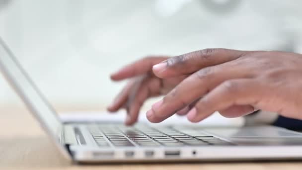 Vista lateral de los dedos africanos escribiendo en el ordenador portátil — Vídeo de stock