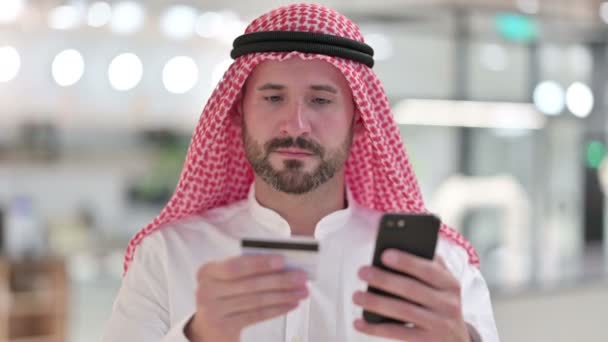 Арабский бизнесмен, осуществляющий онлайн-платежи на смартфоне — стоковое видео