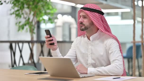 Experto hombre de negocios árabe con computadora portátil usando Smartphone — Vídeos de Stock