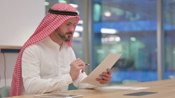 Hardwerkende Arabische zakenman die documenten leest — Stockvideo