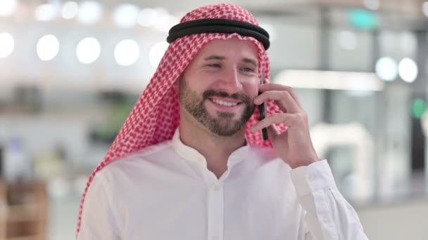 Веселый арабский бизнесмен разговаривает по смартфону — стоковое видео