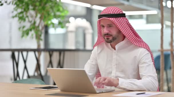 Возбужденный арабский бизнесмен празднует успех на ноутбуке — стоковое видео